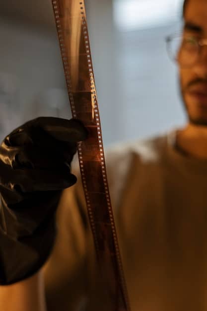 A close-up shot of a film reel being inspected by a technician. The technician is wearing gloves and using specialized equipment to assess the condition of the film. The background is filled with shelves of archival film containers.