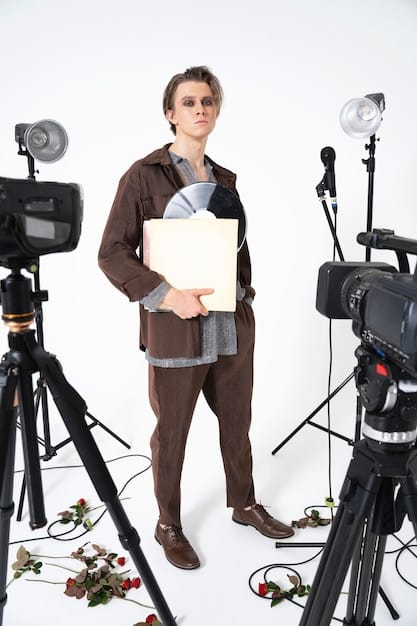 A filmmaker standing in front of a camera, explaining a complex technical setup to a crew member. The background shows various pieces of equipment, emphasizing the technical challenges of documentary filmmaking.