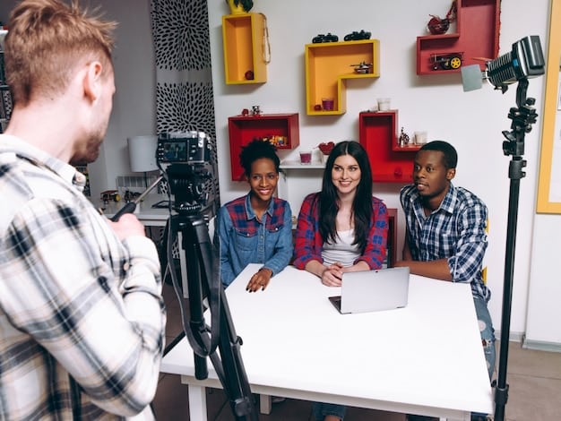 A shot of a diverse group of film students collaborating on a project. The students are reviewing footage on a laptop, with scripts and storyboards scattered around them. The setting is a modern, well-equipped classroom within the film school.