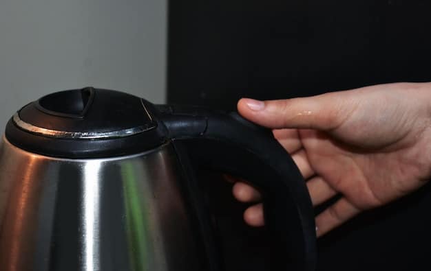 A hand demonstrating the automatic shut-off feature of an electric kettle, showing the kettle turning off immediately after the water boils in a modern kitchen setting in Nigeria.