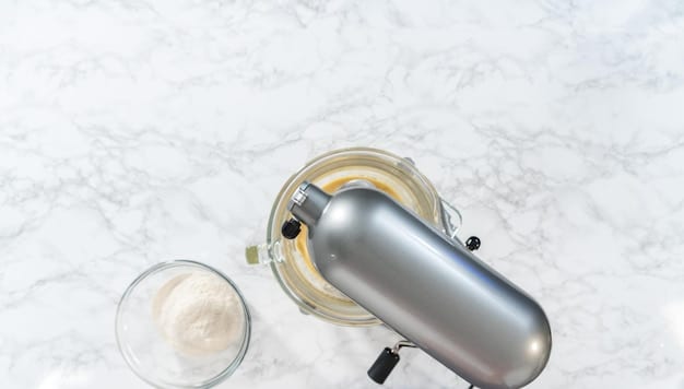 A top-down view of the Philips HD9306/03 electric kettle in a modern kitchen. The stainless steel interior is visible, and the kettle is sitting on its 360-degree swivel base. A hand is reaching to pour hot water into a mug.