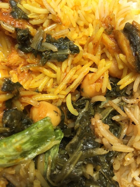 A close-up shot of a smartphone camera capturing a detailed, vibrant image of a local Nigerian dish (e.g., Jollof rice). The background is blurred, highlighting the food's texture and colors.